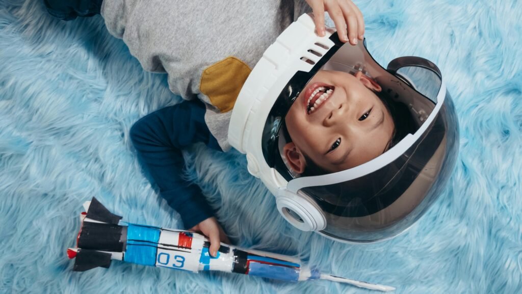 Defining Social-Emotional Learning (SEL) A cheerful child in astronaut costume pretends space adventures on a soft carpet.