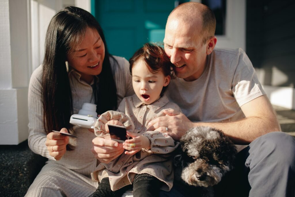 How to Choose the Best Family Language Strategy for Raising Bilingual Kids A multicultural family capturing a joyful moment outdoors with their child and pet.